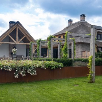 Tuinontwerp met robuuste boogvormen en cortenstaal.